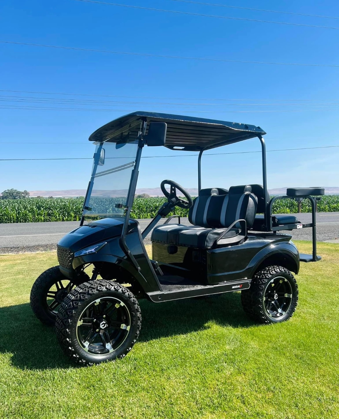 Black lifted custom golf cart with off-road tires
