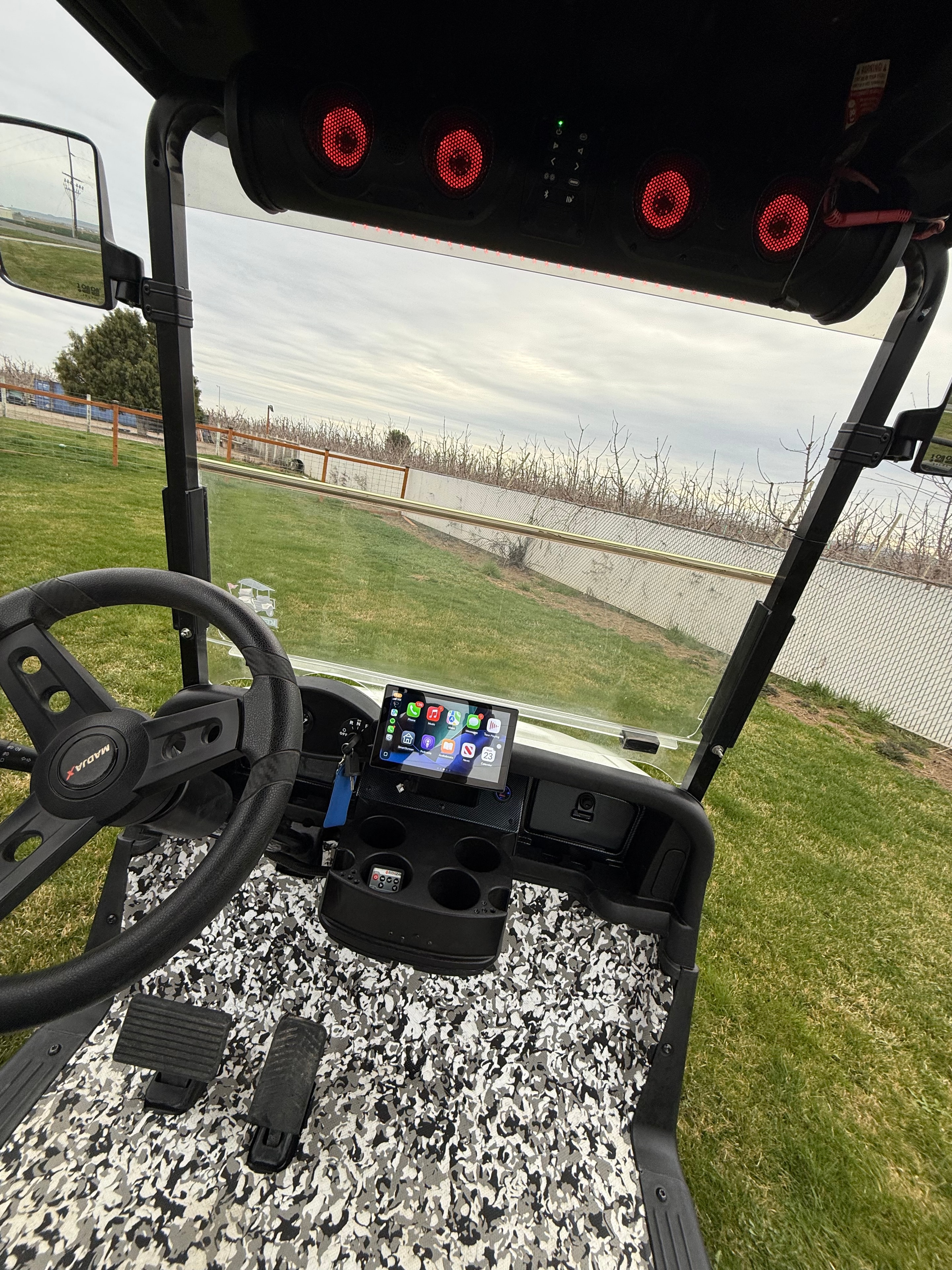 Golf cart cockpit with camo seating and red illuminated speakers