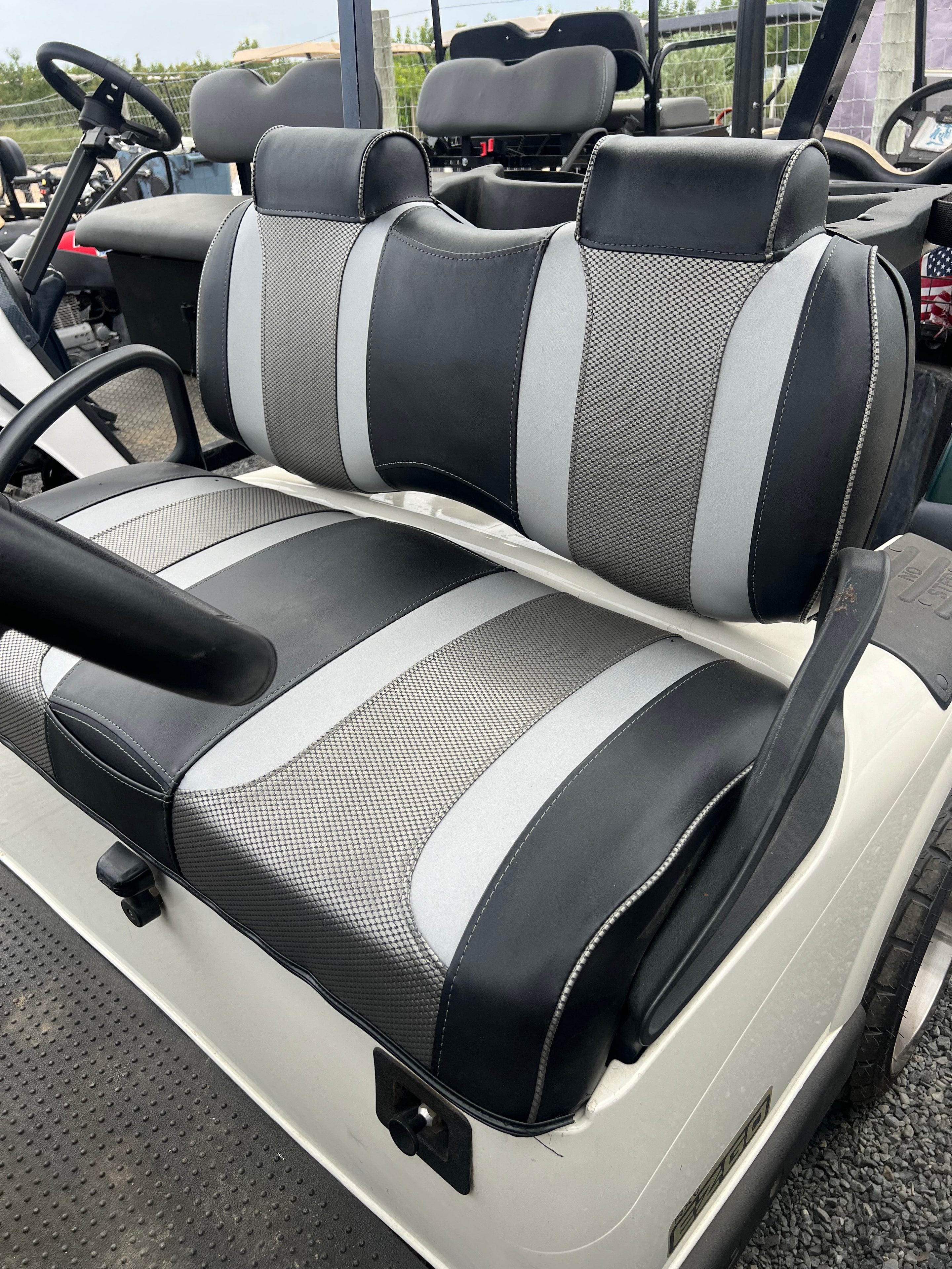 White golf cart with gray and carbon fiber custom seats