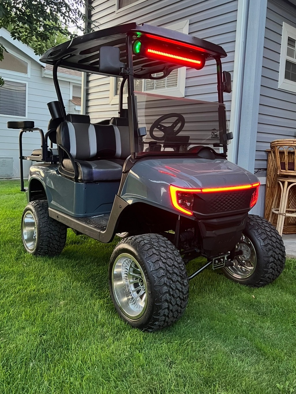 Gray lifted golf cart with red LED lighting