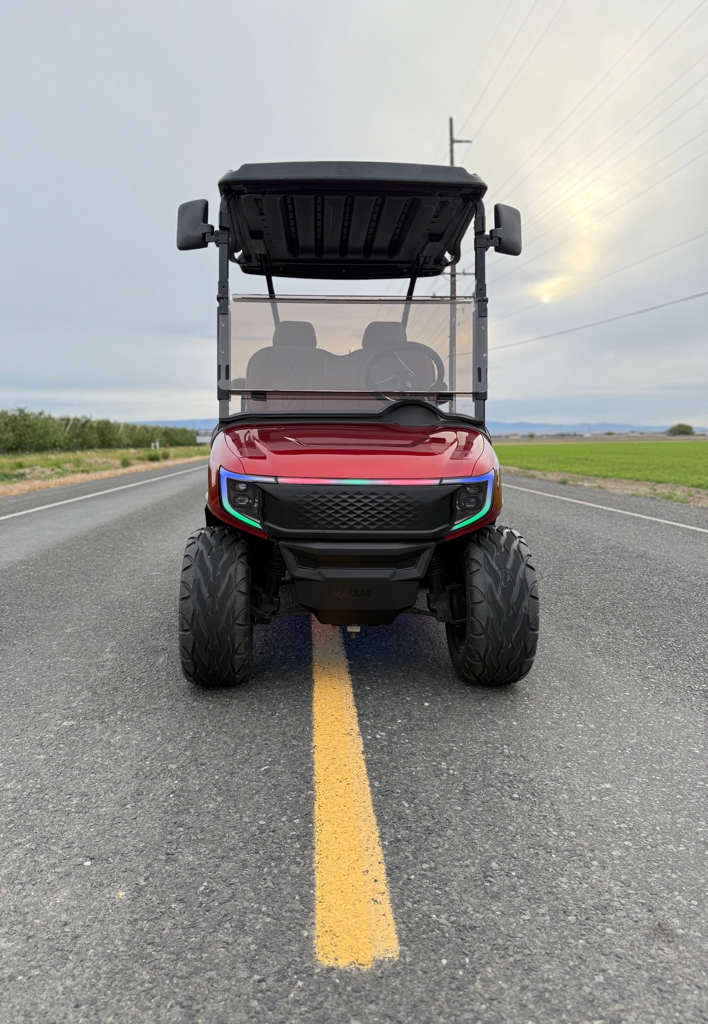 Red golf cart parked on a rural road