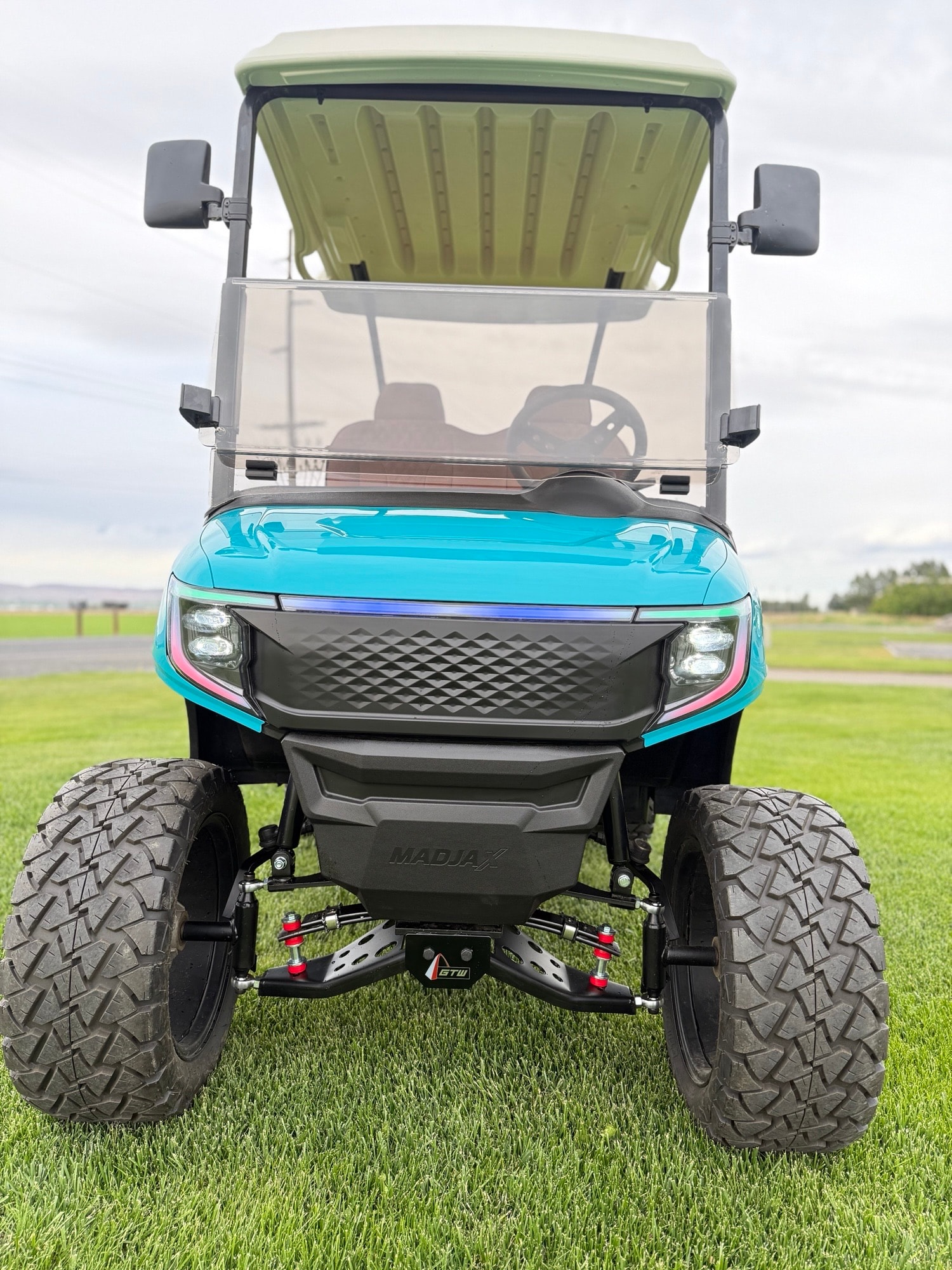 Turquoise off-road golf cart on grass