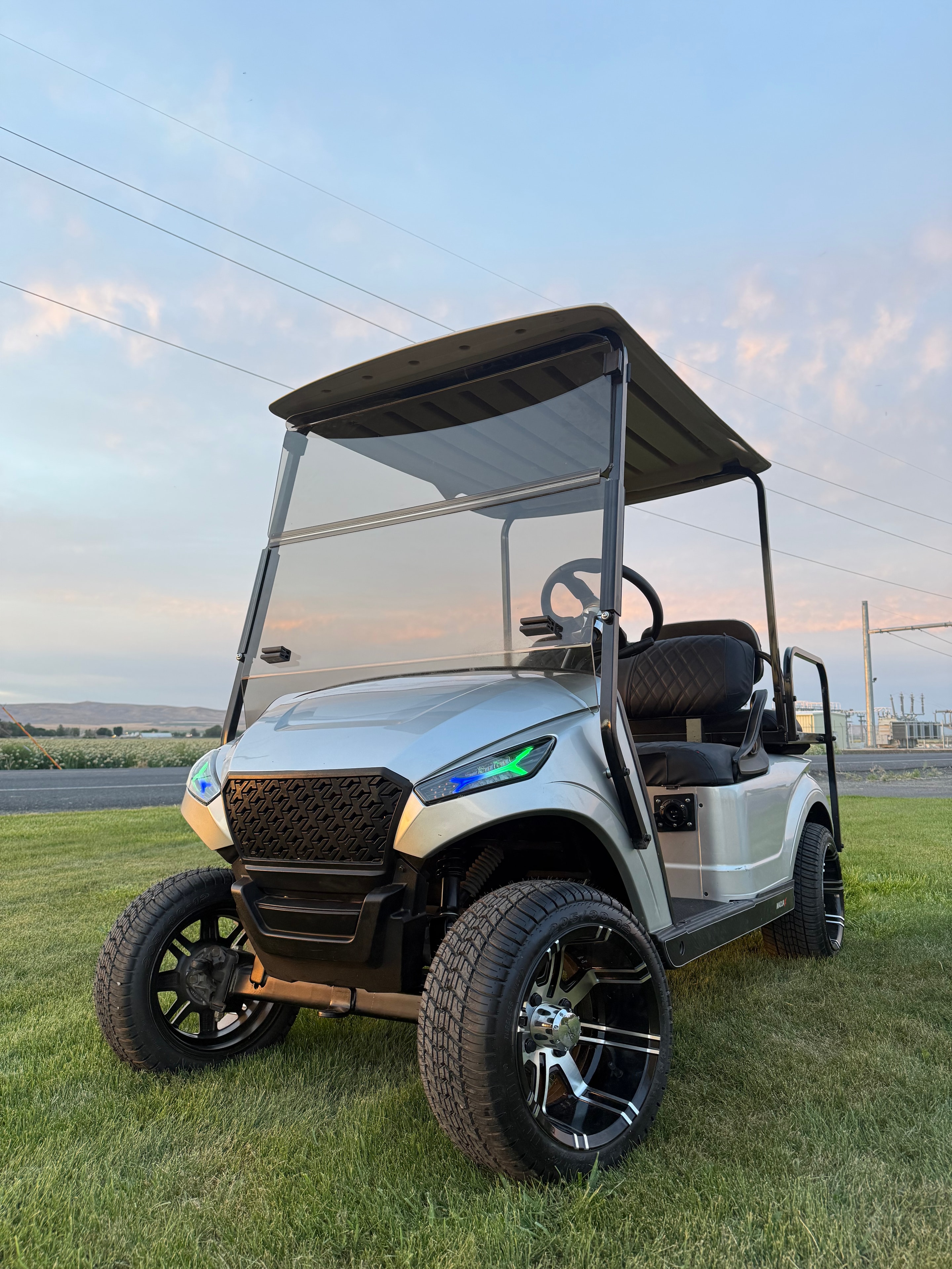 White custom golf cart with black wheels and accent lighting