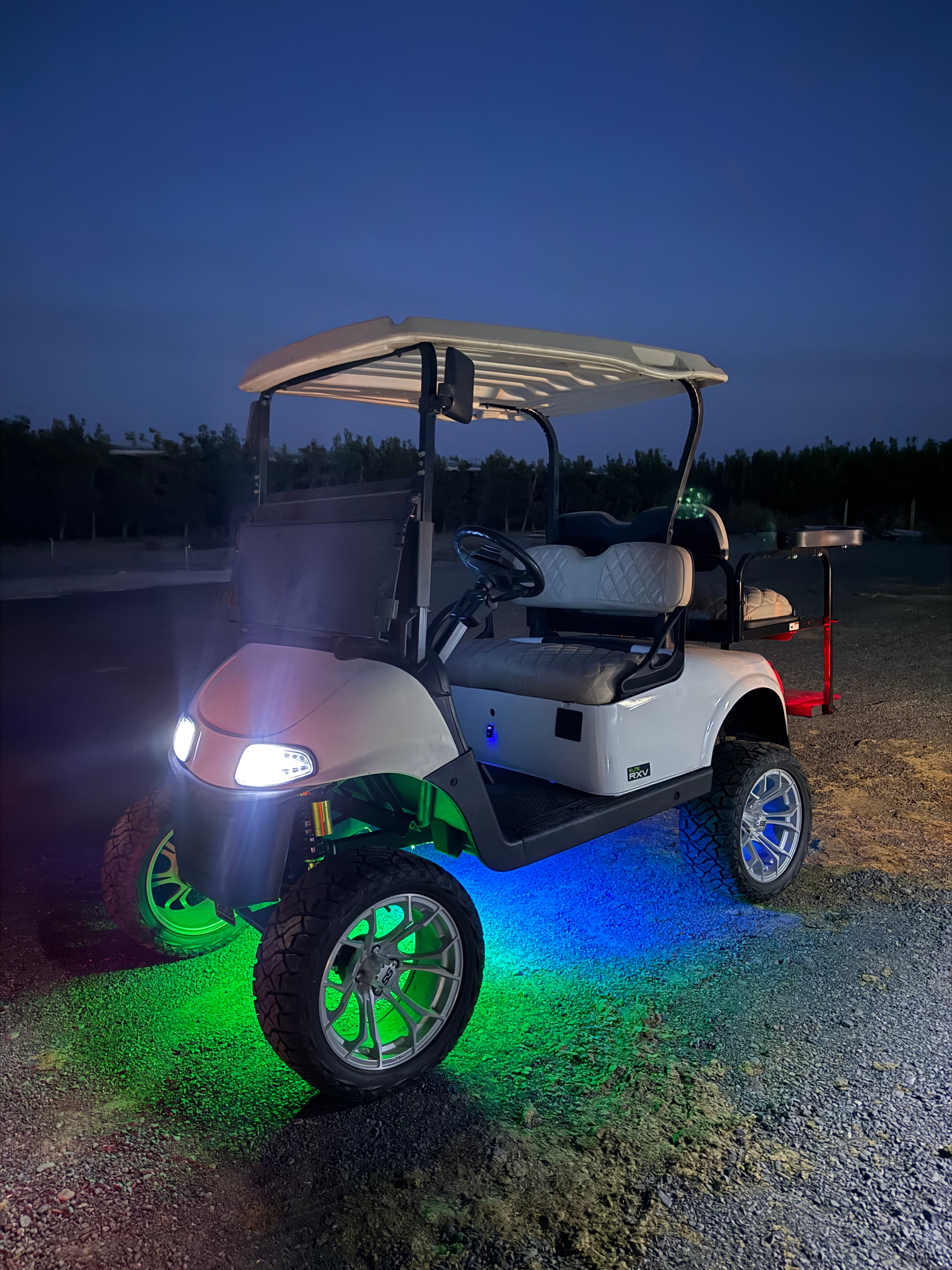 White custom golf cart with blue and green LED underglow