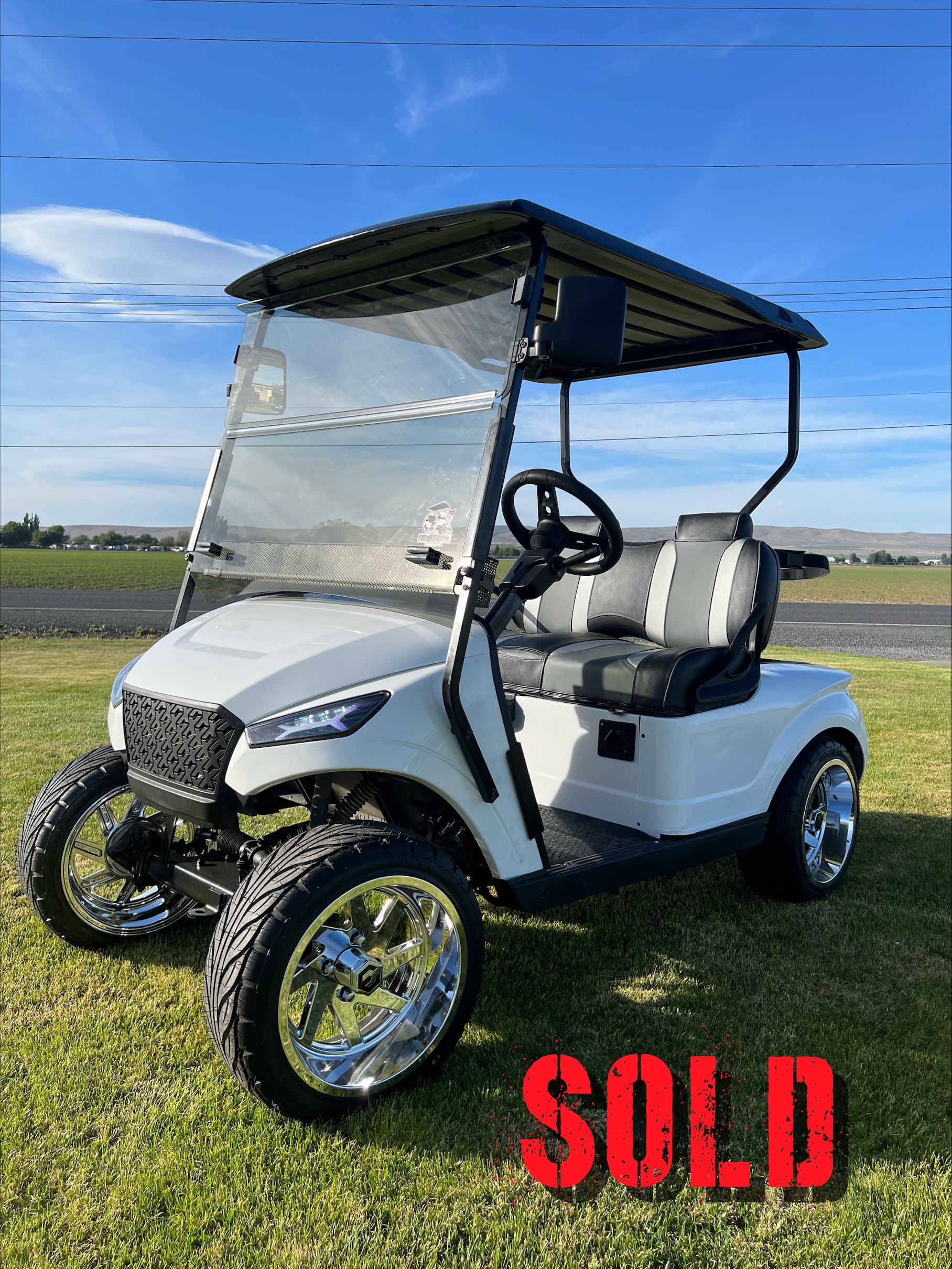 White golf cart parked on grass
