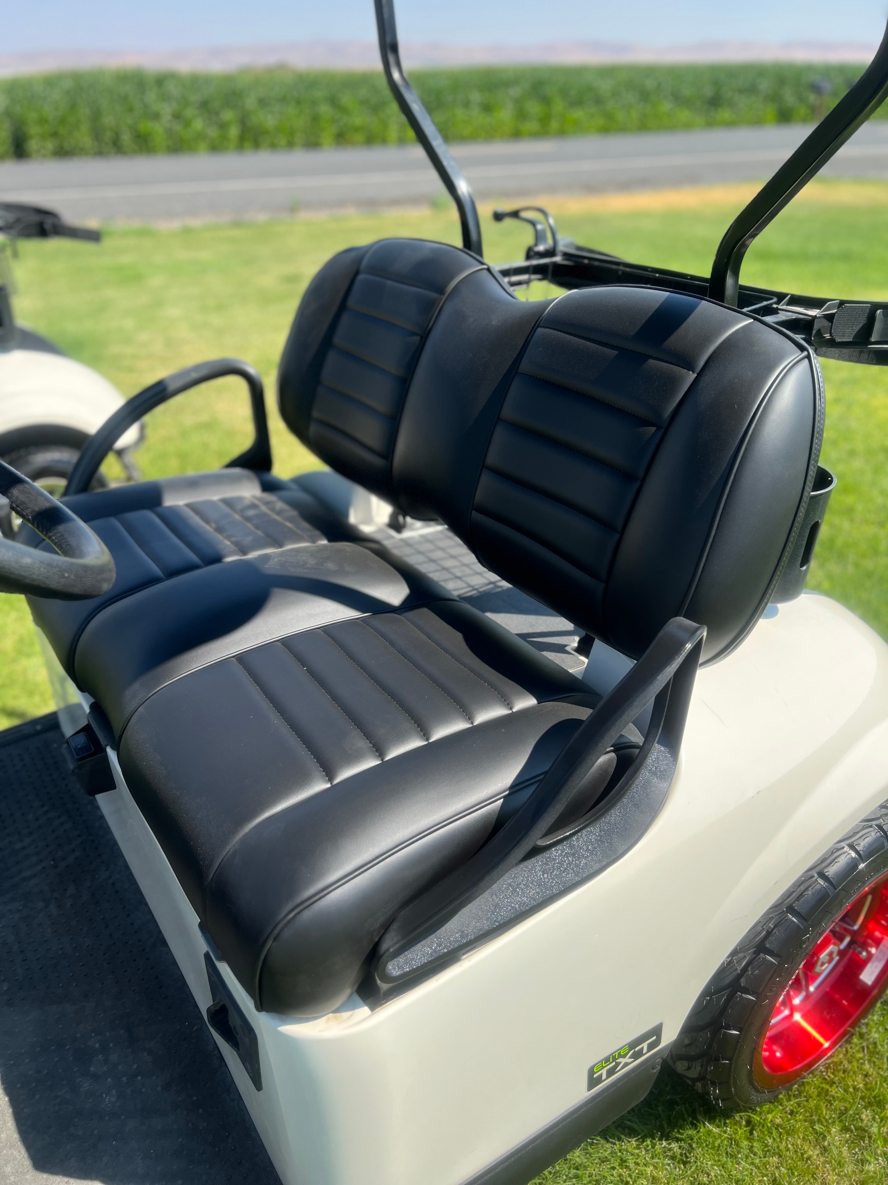 White lifted custom golf cart with black seats and blue accent lighting